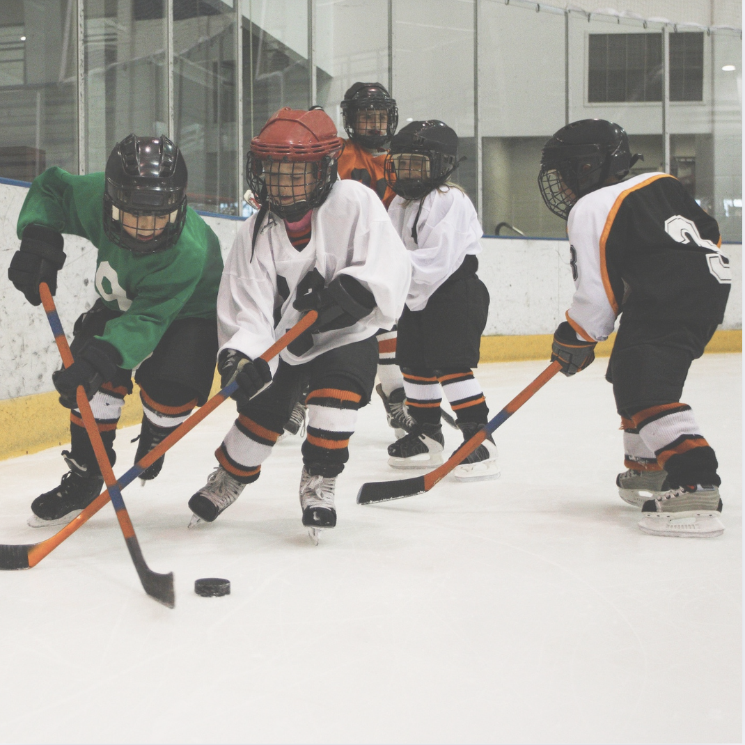 Young hockey players in action on the ice, highlighting the need for sports chiropractic care to support strength, mobility, and injury prevention in young athletes.